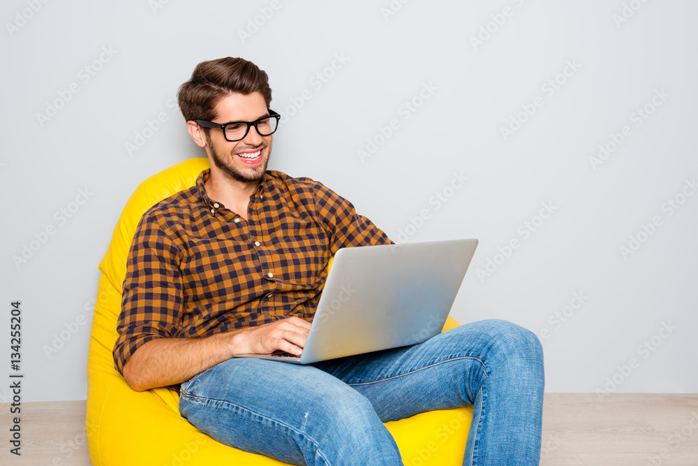 Portrait of handsome smiling man in glasses working on laptop Portrait of handsome smiling man in glasses working on laptop