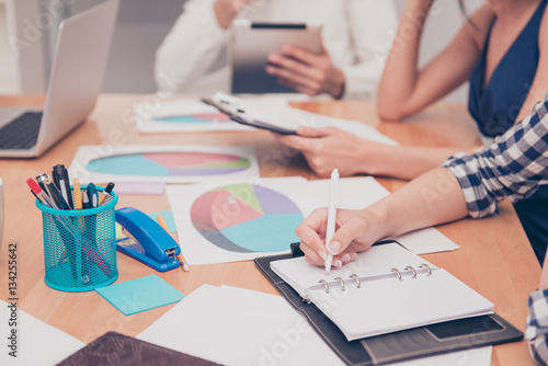 Close up of woman making notes on business meeting