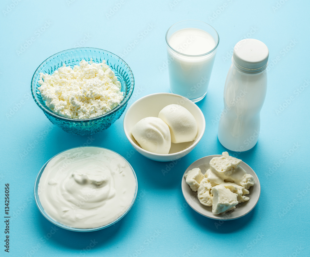 Protein products: cheese, cream, milk, eggs on the blue backgrou Protein products: cheese, cream, milk, eggs on the blue backgrou