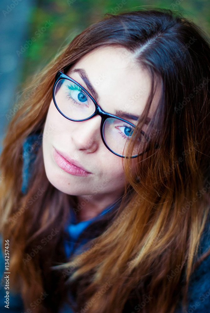 Fototapeta premium Sad beautiful girl in glasses with blue eyes.