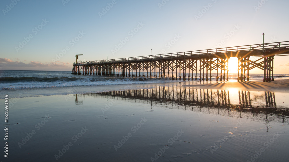 Fototapeta premium Pier with Reflection During Sunset and Low Tide in Gaviota State Park, California