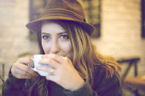 Attractive, stylish woman drinking coffee at cafe