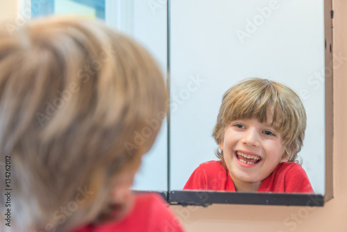 Young boy looking at himself in mirror
