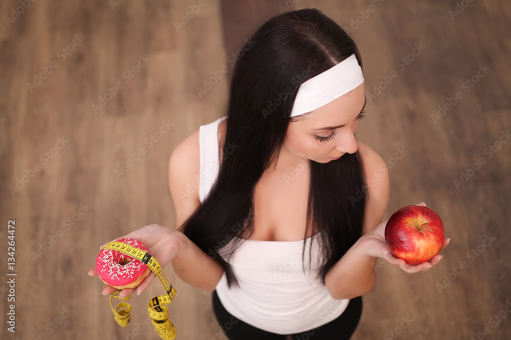 Diet. Dieting concept. Healthy Food. Beautiful Young Woman choosing between Fruits and Sweets Diet. Dieting concept. Healthy Food. Beautiful Young Woman choosing between Fruits and Sweets