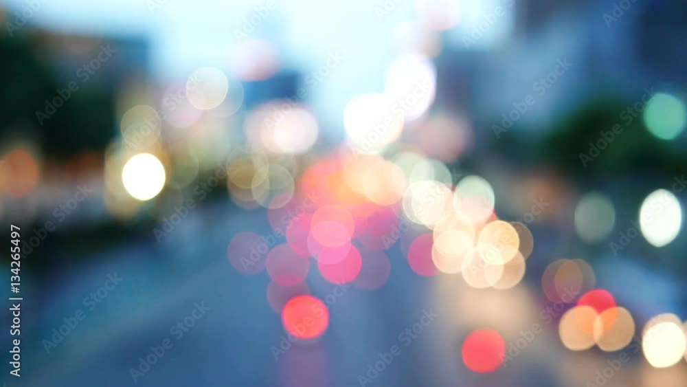Defocused traffic and city lights on urban big street at dusk.