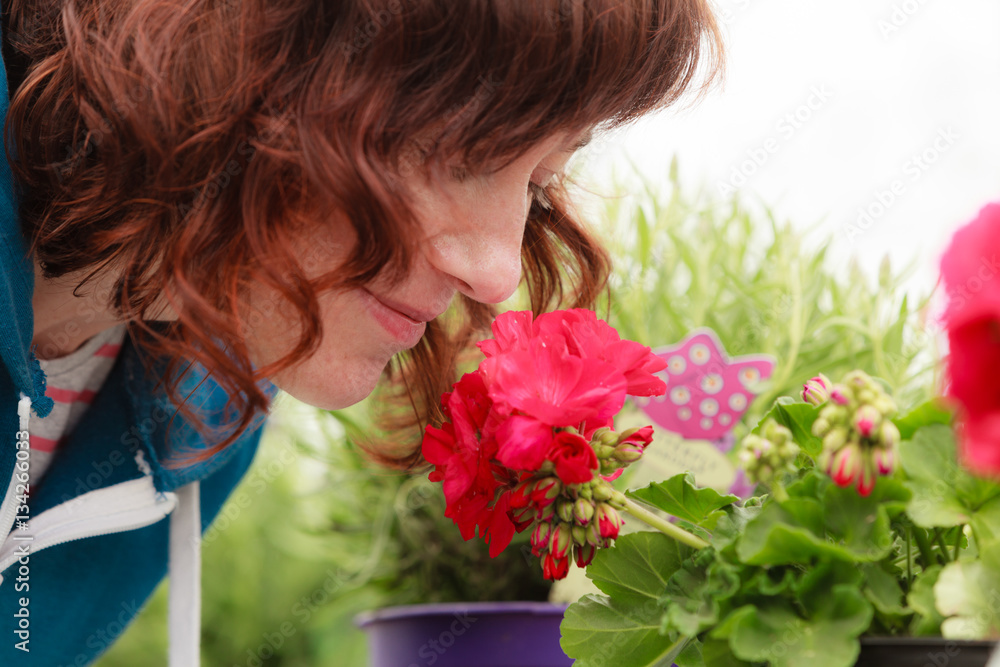 Fototapeta premium Woman smelling red flowers, roses
