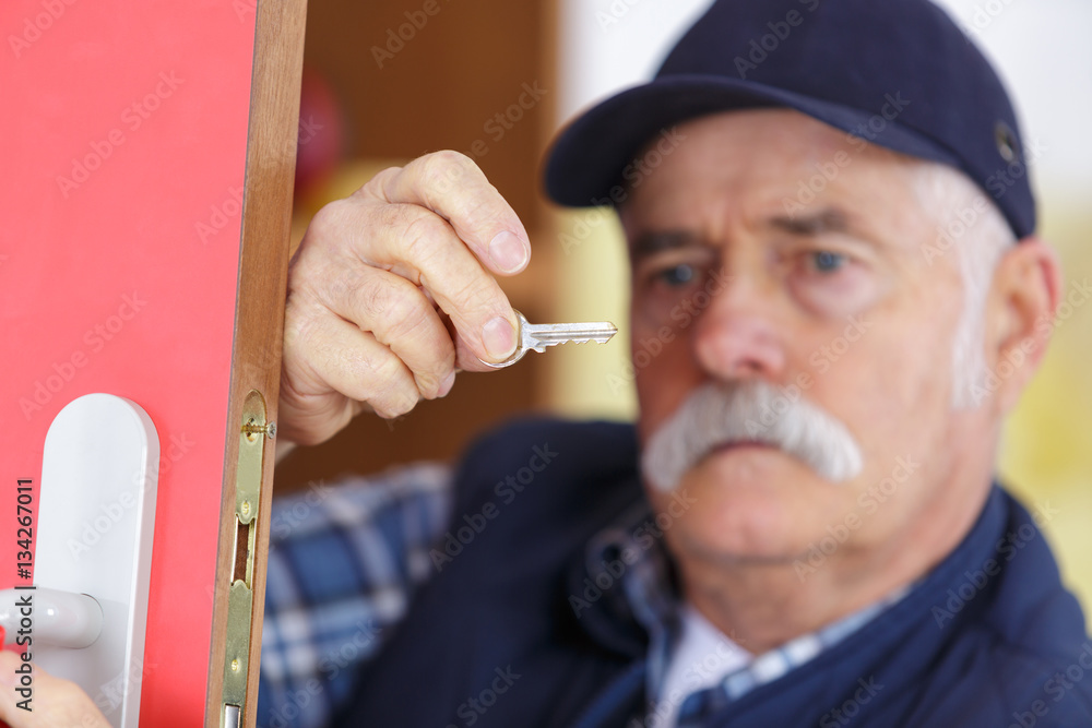 senior man repairing gate lock