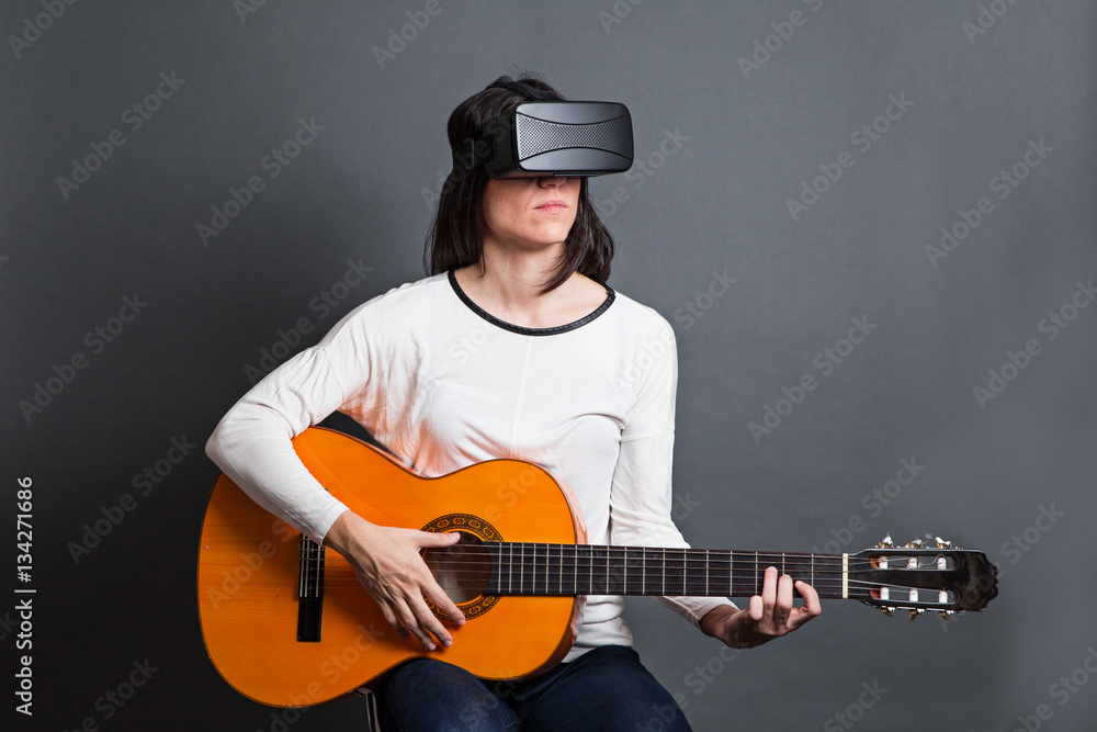 young woman learning how to play the guitar through virtual real young woman learning how to play the guitar through virtual real