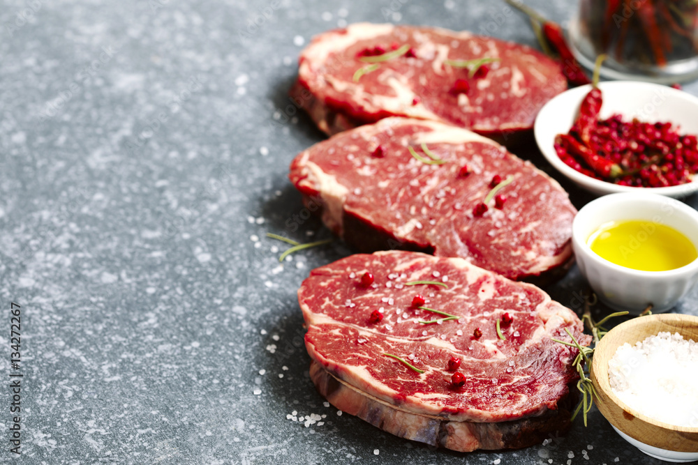 Raw fresh meat Ribeye Steak with rosemary, pepper, salt and olive oil