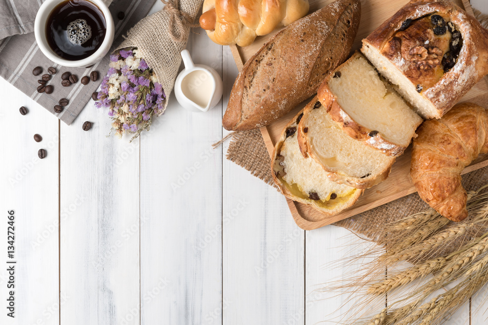Top view of baked bread and wheat on white wood background Top view of baked bread and wheat on white wood background