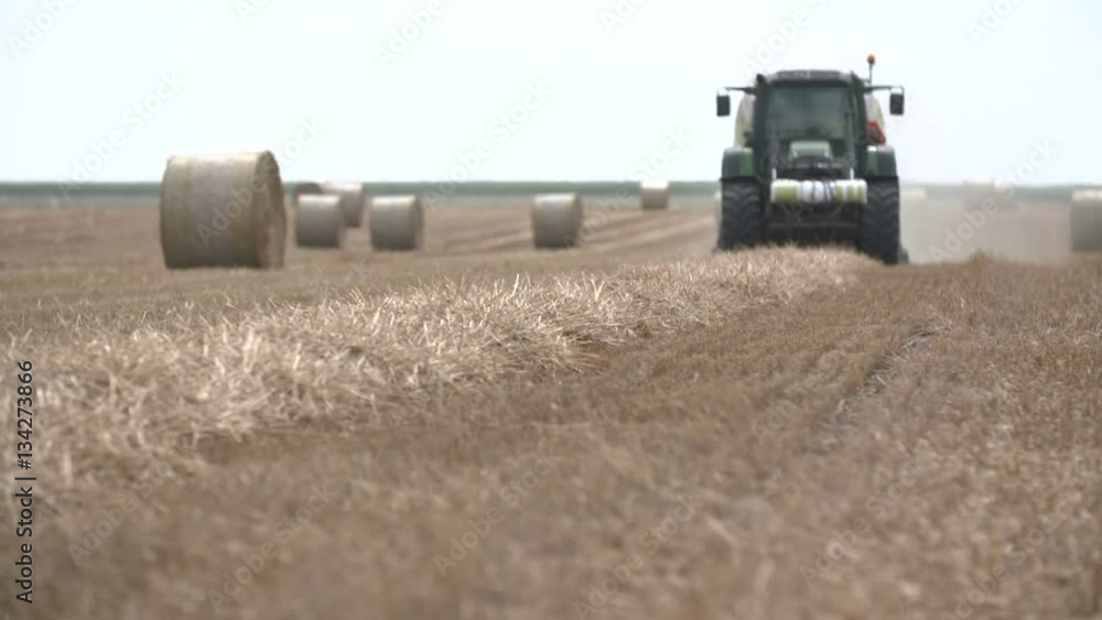bales of hay, tractor working in field bales of hay, tractor working in field