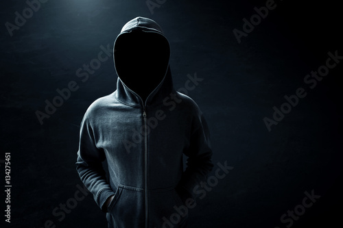 Hacker standing alone in dark room