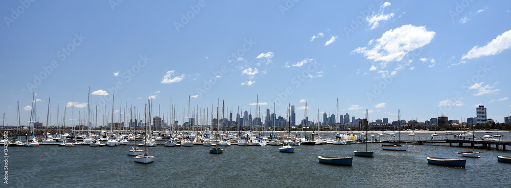 Melbourne skyline from St Kilda (Victoria Australia). View from a wooden jetty over the city of Melbourne in the Port Phillip Bay in Victoria and many yachts on the quay.