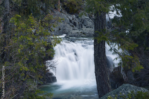 Long exposure of a small waterfall full of spring snowmelt in a granite canyon in the Trinity Alps