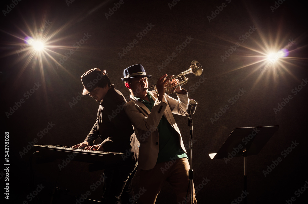 Musician Duo band playing a Trumpet and keyboard on black backgr