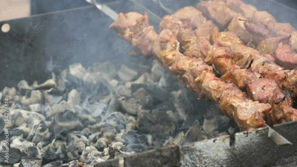 Cooking of pork skewers on metal skewers on coals outdoors. Close up