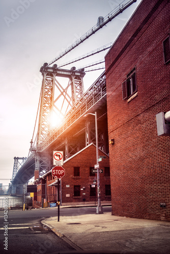 Quadro su tela New York City street in Brooklyn with view to Williamsburg Bridge at sunset time