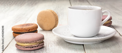Cup of coffee with pastel colored macarons and copyspace
