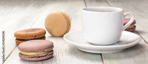 Fotografie Cup of coffee with pastel colored macarons and copyspace