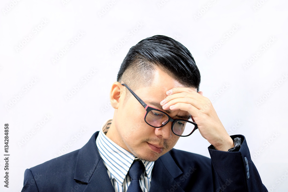Asian business man with a headache from disappointment isolated on a white background. Asian business man with a headache from disappointment isolated on a white background.