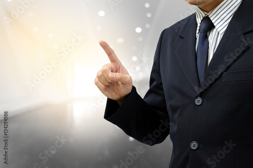 Asian business man finger point up on abstract blurry background