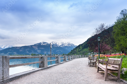 Zeller See Salzburg, Austria. Green grass, tulips blossom. A shop on the bank of the lake.