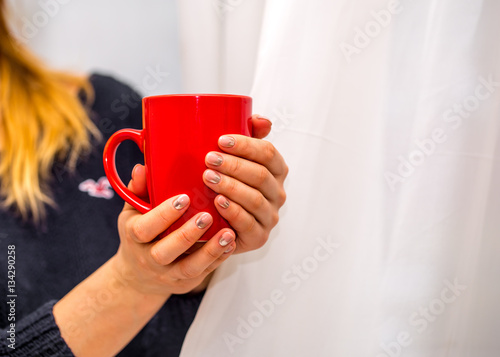 female hands holding a red Cup, close-up