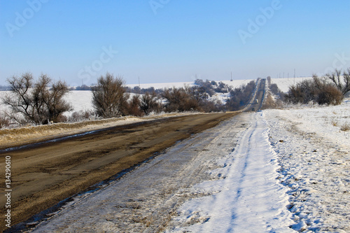 Broken cracked asphalt road on winter