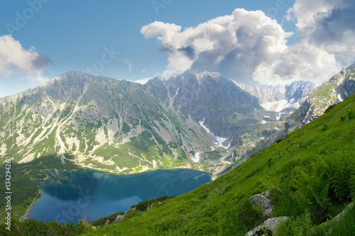 Fototapeta Naklejka Na Ścianę i Meble -  Mountain lake against the mountain slopes and sky