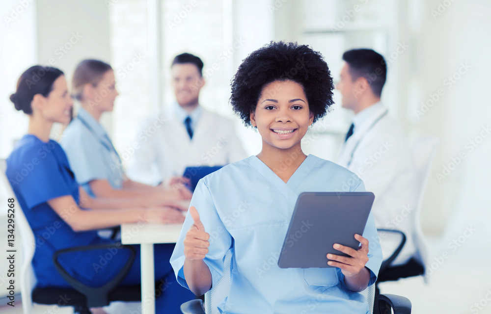 happy doctor with tablet pc over team at clinic happy doctor with tablet pc over team at clinic