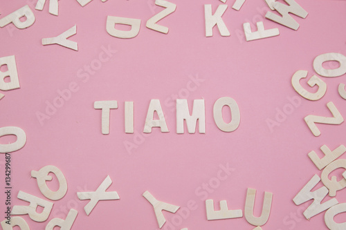 Sorting letters Tiamo on pink. photo