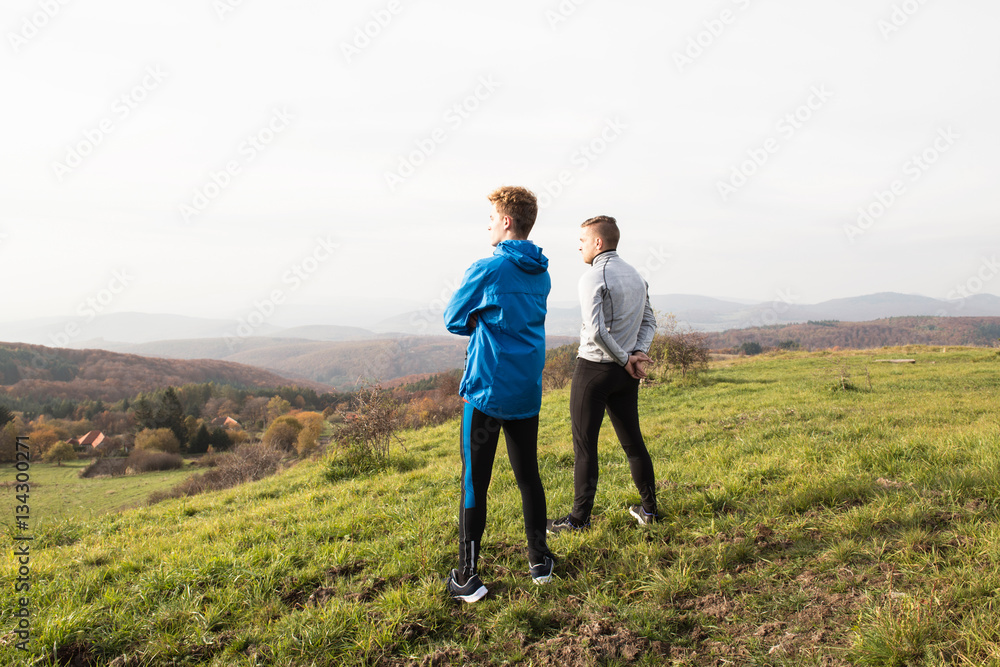 Two young hipster runners in sunny autumn nature restinng Two young hipster runners in sunny autumn nature restinng