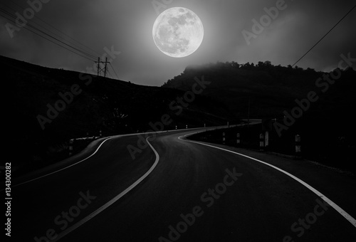Landscape of nighttime with curvy roadway in forest.