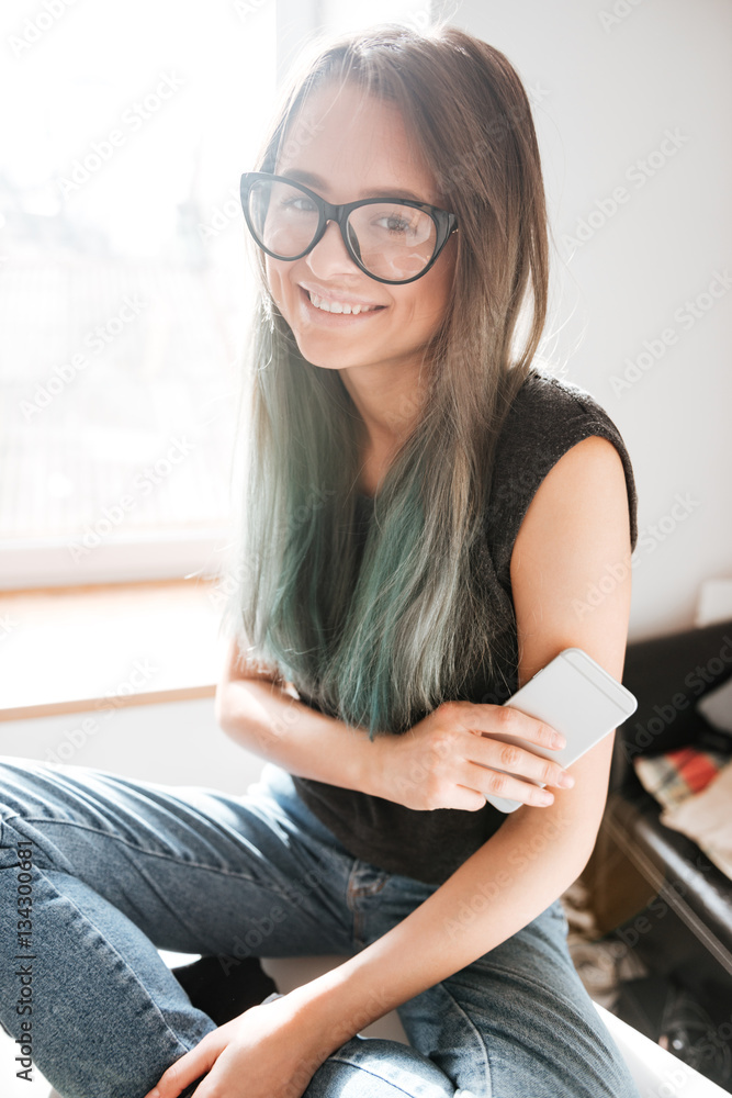 Happy woman sitting on the table and using cell phone Happy woman sitting on the table and using cell phone