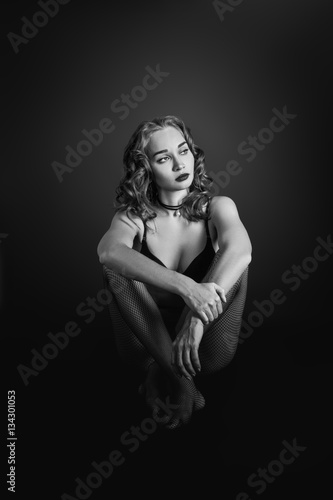 beautiful sensual luxury woman in lingerie sitting on black background, monochrome