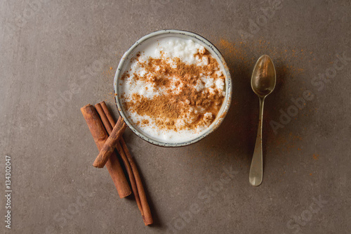 Traditional rice pudding with cinnamon. Dark background. Tasty a photo