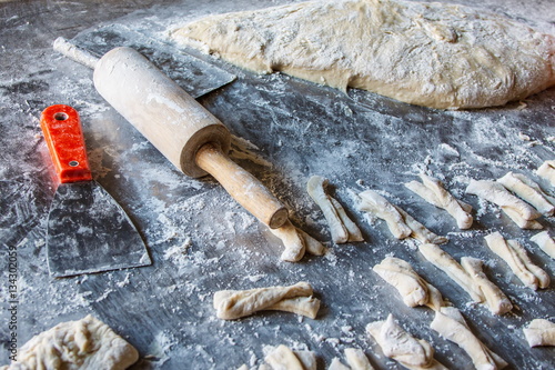 Rolling pin with dough and flour for making deep-fried dough stick in market