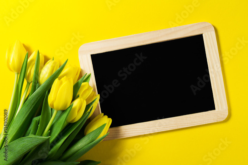Fresh beautiful yellow tulips on yellow colorful background with