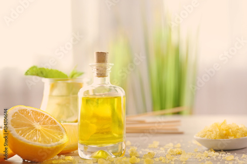 Beautiful spa composition with lemon essential oil on gray table  closeup