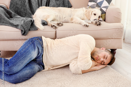 Cool dog and young man sleeping at home