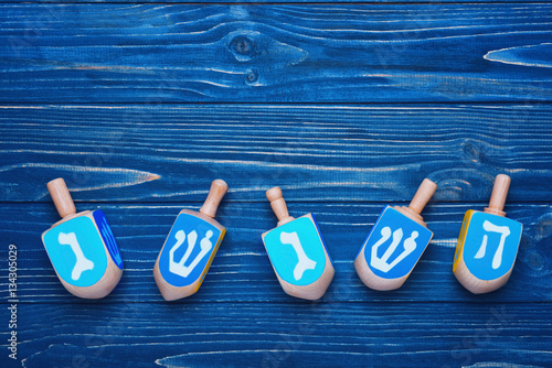 Dreidels for Hanukkah on blue wooden table
