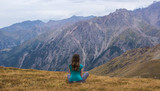 Woman are sitting in yoga style at the mountains, Tien Shan moun
