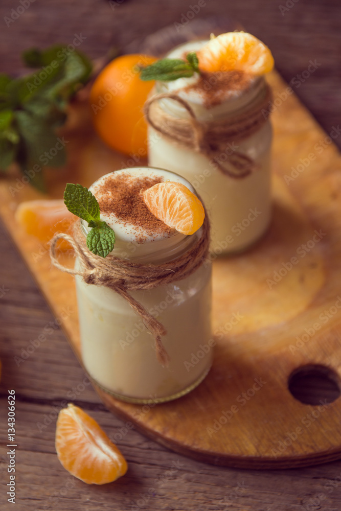 Fresh organig natural white yogurt in glass jars with tangerine Fresh organig natural white yogurt in glass jars with tangerine