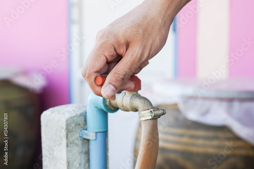 close up man turn water tap off for saving environment