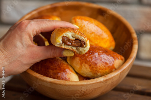 Traditional russian patties in a bowl on a wooden background.