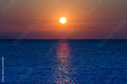 sunrise at sea on a background of mountains