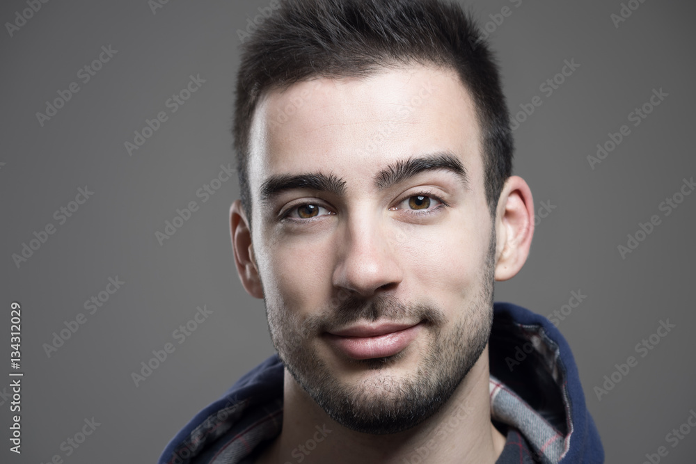 Close up horizontal portrait of young unshaven man wearing hoodie looking at camera Close up horizontal portrait of young unshaven man wearing hoodie looking at camera