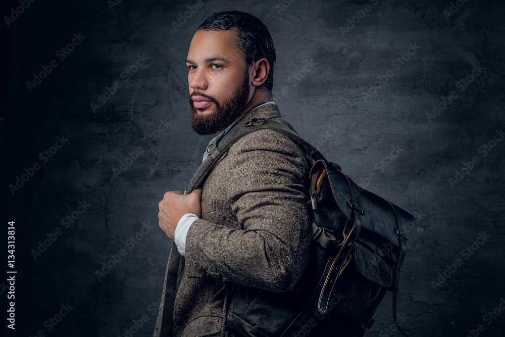 Black man in a suit holds backpack. Black man in a suit holds backpack.