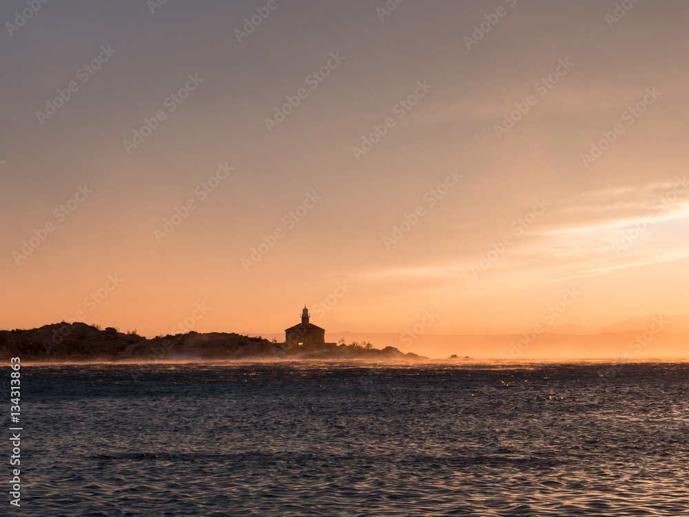 Lighthouse at sunset on storm