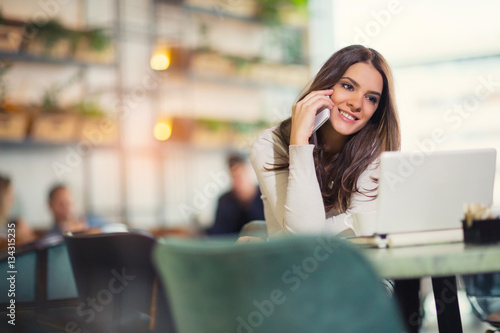 Young gorgeous woman having smart phone conversation while 
